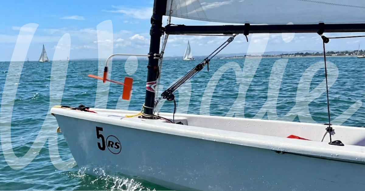 ILCA dinghy side wind indicator mounted upside down below the boom at a crowded start line