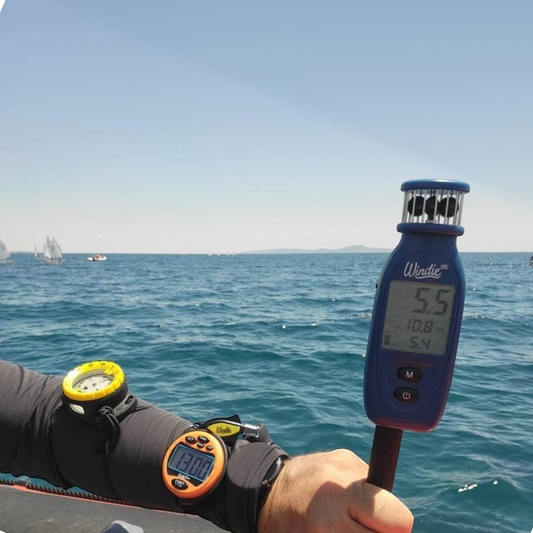 Windie.pro Pin End Kit with anemometer and sailing timer on wrist, used for race management on the water.