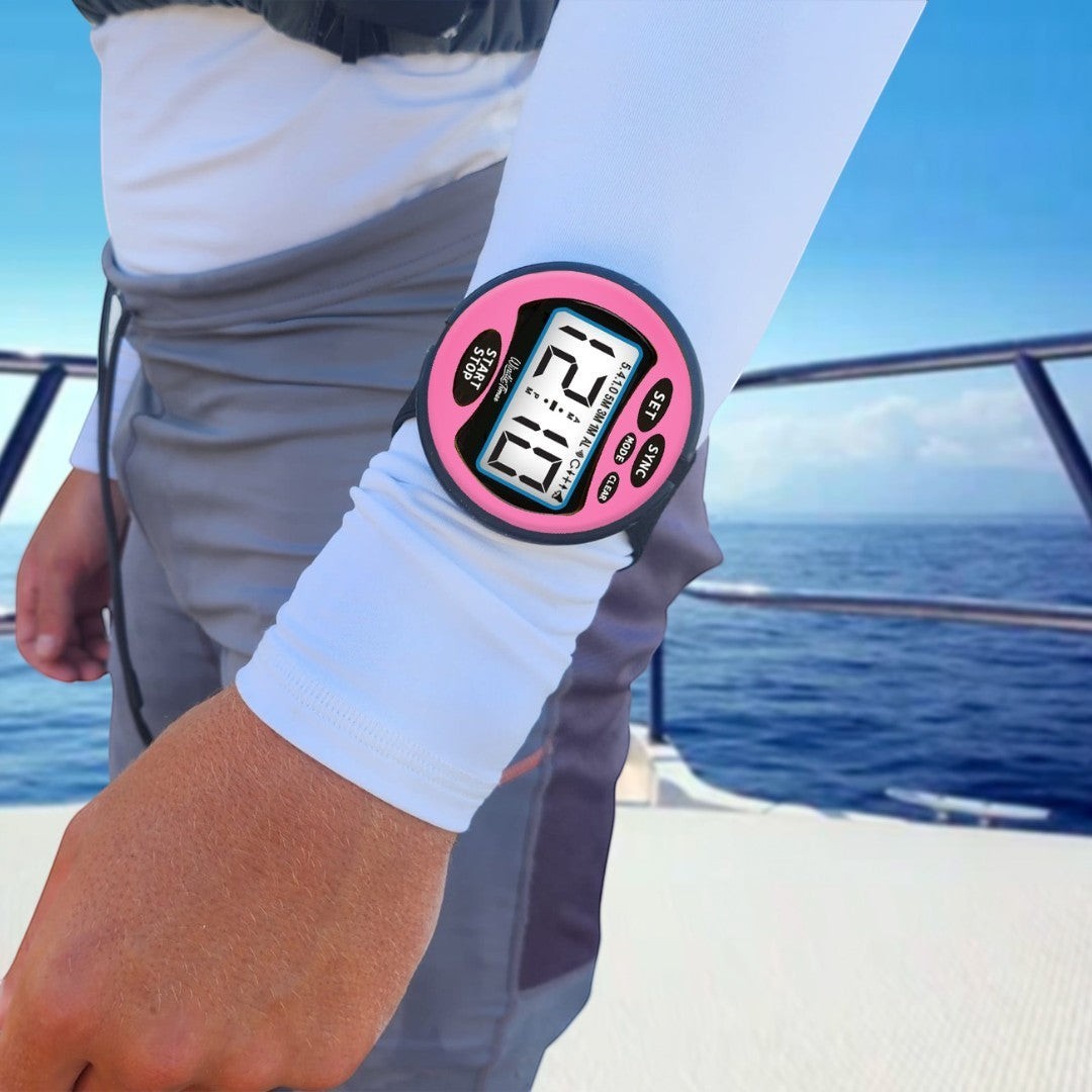 Windie.pro pink sailing race stopwatch with digital display and 5-4-1-0 count, worn on arm over white sleeve.