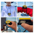 windie.pro waterproof bearing compass with yellow bezel and lanyard, shown worn by a man and held by a hand on a boat.